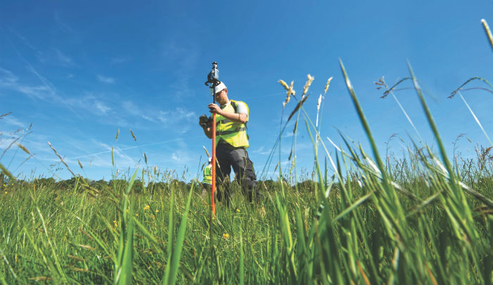 green-field-blue-sky-engineer-measuring